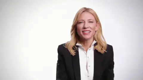 GIF: Frau im schwarzen Blazer lacht und klatscht in die Hände