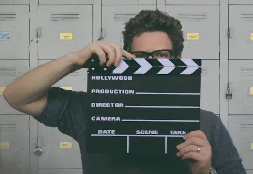 GIF: Mann mit Filmklappe vor Spinden